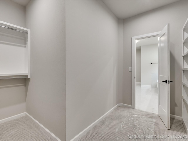 hallway featuring carpet floors and baseboards