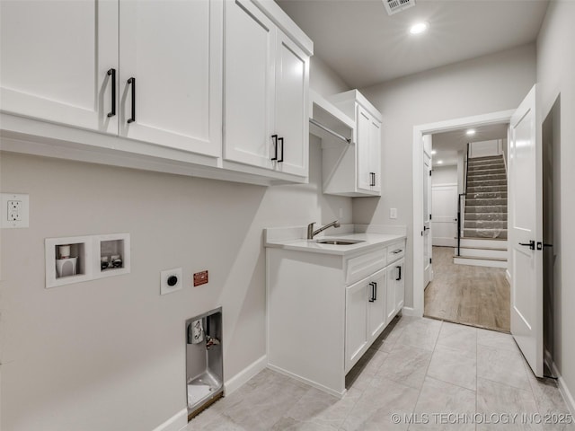 clothes washing area with a sink, hookup for an electric dryer, cabinet space, baseboards, and washer hookup