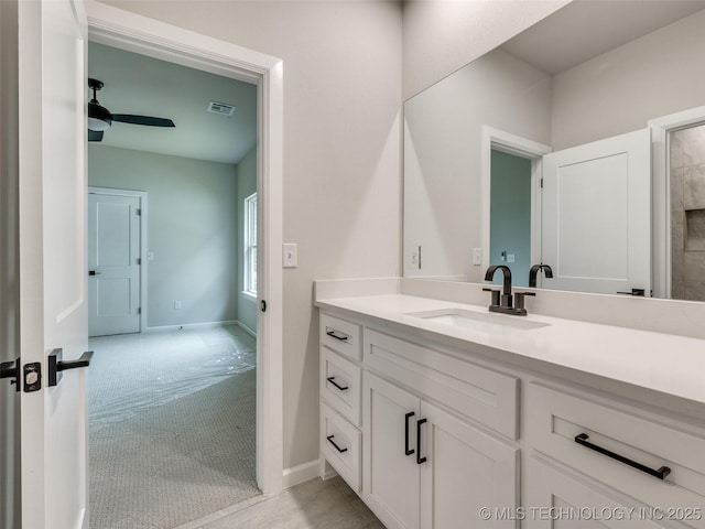 bathroom with baseboards, visible vents, vanity, and ceiling fan