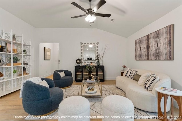 living area featuring visible vents, baseboards, lofted ceiling, ceiling fan, and light wood-style floors