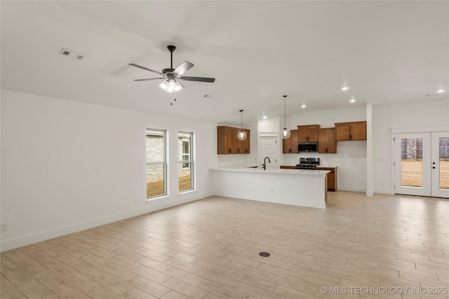 unfurnished living room featuring ceiling fan and sink