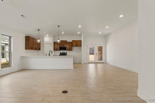 kitchen with french doors, stainless steel appliances, decorative light fixtures, and sink