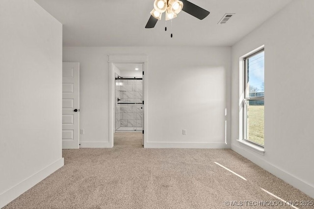 carpeted empty room with a wealth of natural light and ceiling fan