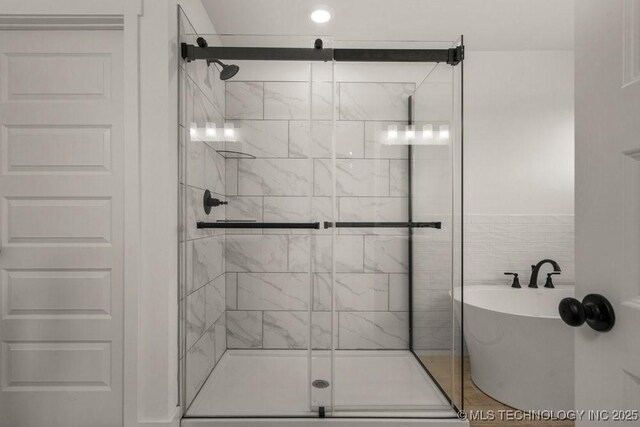 bathroom featuring shower with separate bathtub