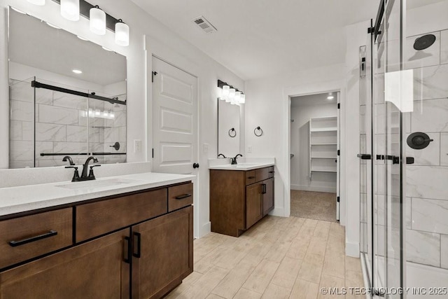 bathroom with vanity and a shower with shower door