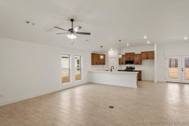 unfurnished living room featuring french doors, ceiling fan, lofted ceiling, and sink