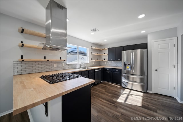 kitchen featuring a breakfast bar, sink, appliances with stainless steel finishes, dark hardwood / wood-style flooring, and kitchen peninsula