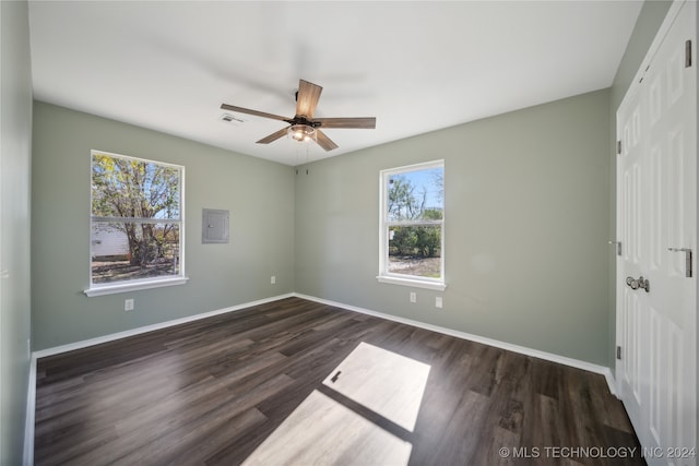 empty room featuring dark hardwood / wood-style floors, ceiling fan, and a wealth of natural light