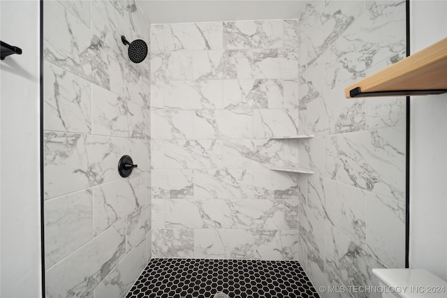 bathroom featuring toilet and a tile shower