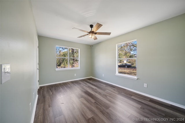 unfurnished room with ceiling fan, a healthy amount of sunlight, and dark wood-type flooring