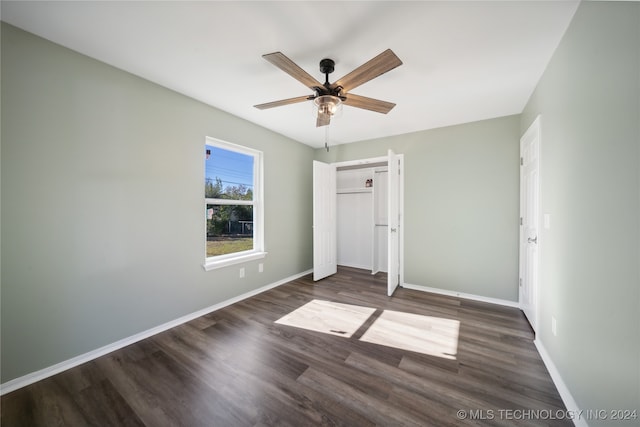 unfurnished bedroom featuring a closet, dark hardwood / wood-style floors, and ceiling fan