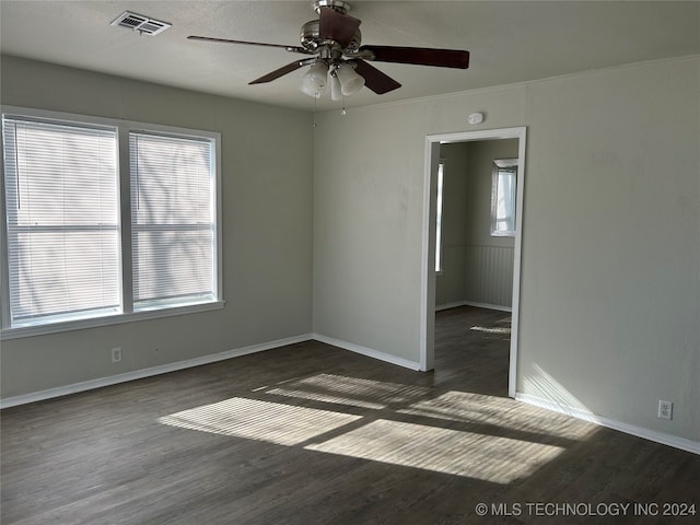 empty room featuring dark hardwood / wood-style floors, ceiling fan, and ornamental molding