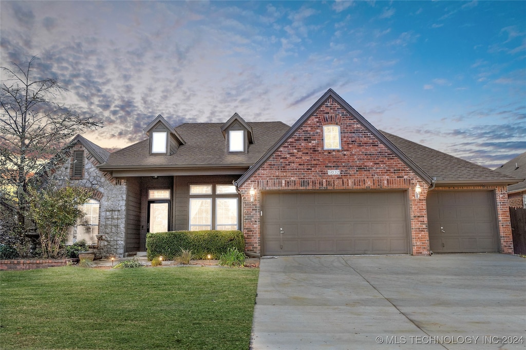 view of front of home with a yard and a garage