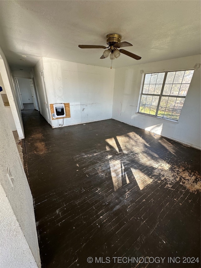 interior space featuring ceiling fan, dark wood-type flooring, and heating unit