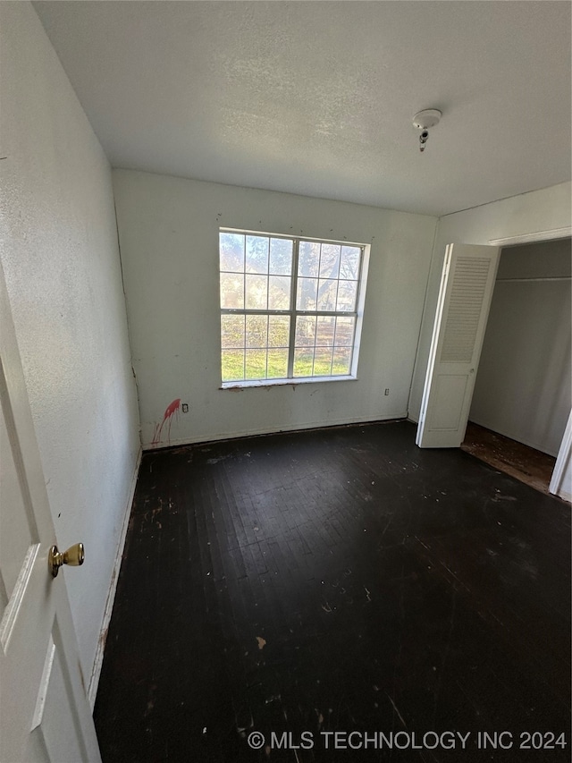 unfurnished bedroom with dark hardwood / wood-style flooring