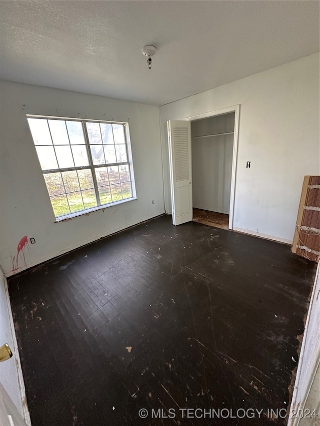 unfurnished bedroom featuring a closet and a textured ceiling