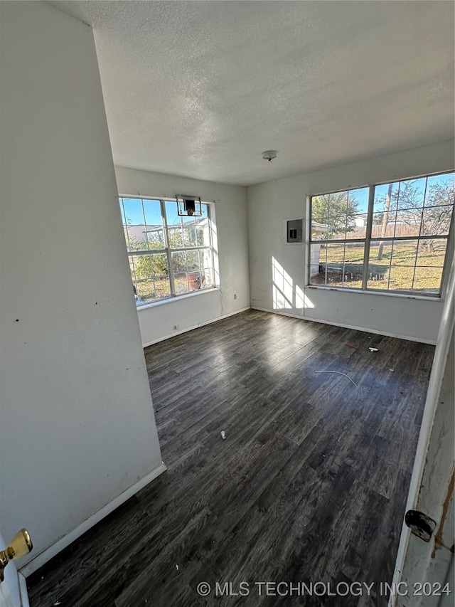 interior space with a textured ceiling, dark hardwood / wood-style floors, and a healthy amount of sunlight