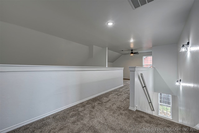 interior space featuring ceiling fan, carpet floors, a wealth of natural light, and vaulted ceiling