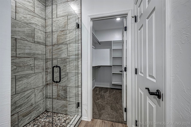 bathroom with hardwood / wood-style floors and walk in shower