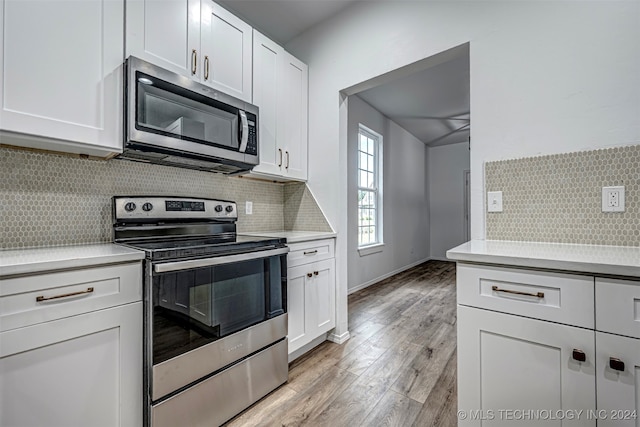 kitchen featuring appliances with stainless steel finishes, light hardwood / wood-style flooring, white cabinetry, and tasteful backsplash