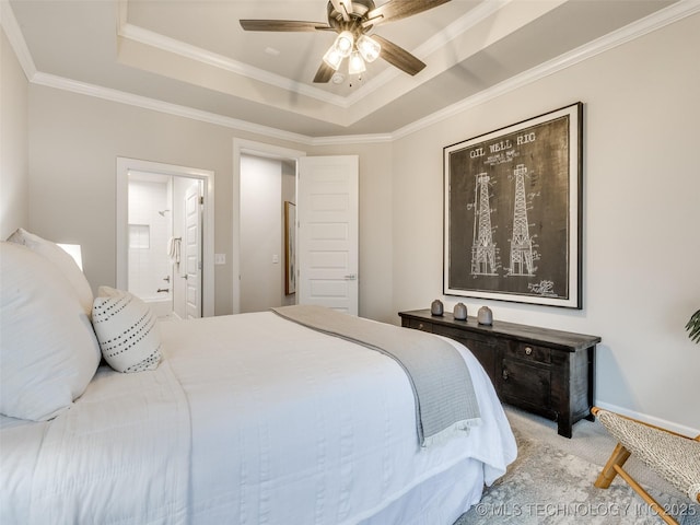 bedroom with a tray ceiling, ensuite bath, ornamental molding, and ceiling fan