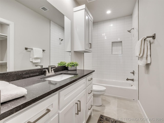 full bathroom with vanity, tile patterned flooring, tiled shower / bath combo, and toilet