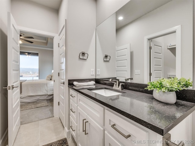 bathroom featuring a raised ceiling, vanity, tile patterned floors, and ceiling fan