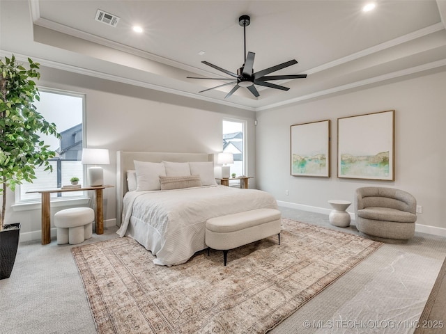 carpeted bedroom with a tray ceiling, ornamental molding, and ceiling fan