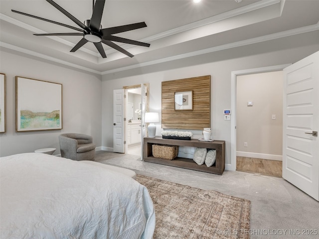 carpeted bedroom with crown molding, connected bathroom, a tray ceiling, and ceiling fan