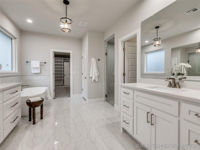 bathroom with vanity and separate shower and tub