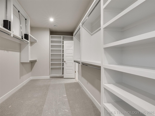 walk in closet featuring light carpet