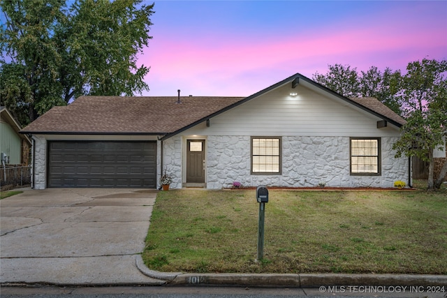 ranch-style home featuring a yard and a garage