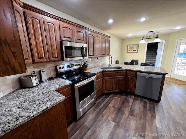 kitchen with backsplash, dark wood-type flooring, sink, kitchen peninsula, and stainless steel appliances