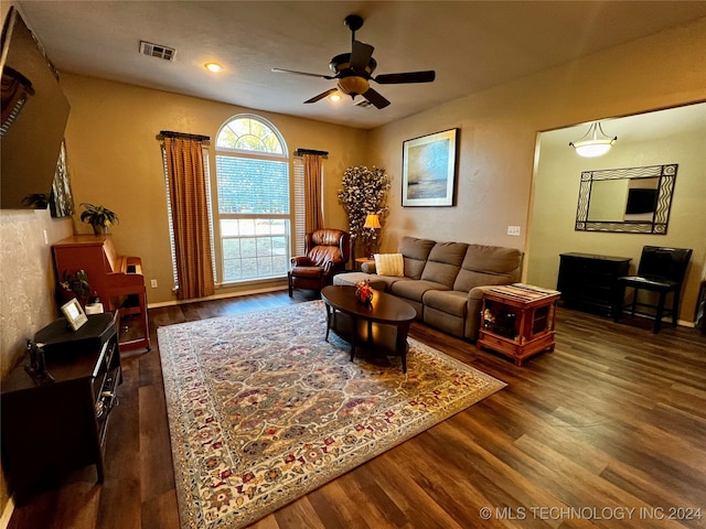 living room featuring ceiling fan and dark hardwood / wood-style floors