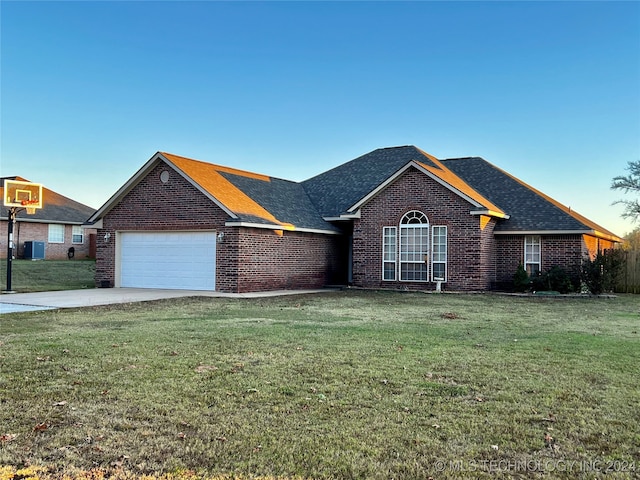 view of front of home with central AC, a garage, and a front lawn