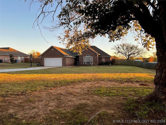 ranch-style home featuring a yard and a garage