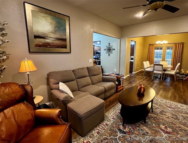 living room featuring ceiling fan with notable chandelier and hardwood / wood-style flooring