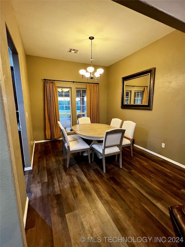 dining room featuring an inviting chandelier and dark wood-type flooring