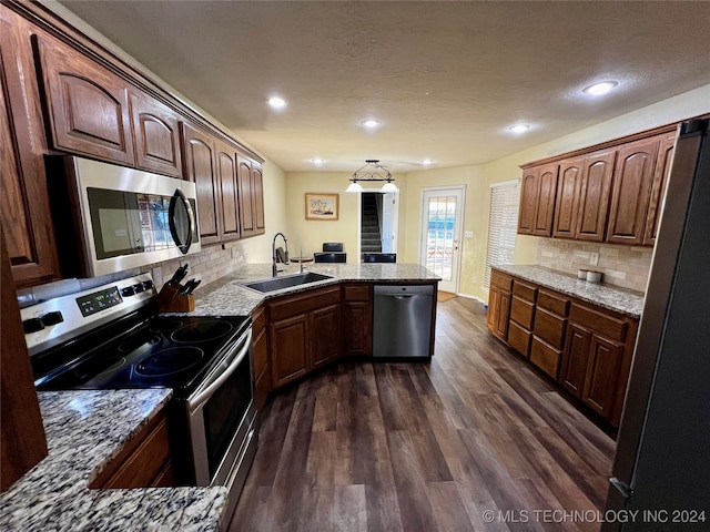 kitchen featuring sink, stainless steel appliances, dark hardwood / wood-style floors, kitchen peninsula, and decorative backsplash