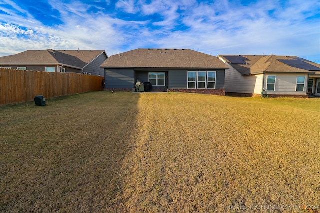 back of house featuring solar panels and a yard