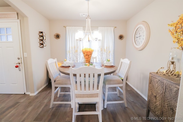 dining space with a wealth of natural light, dark hardwood / wood-style flooring, and a notable chandelier