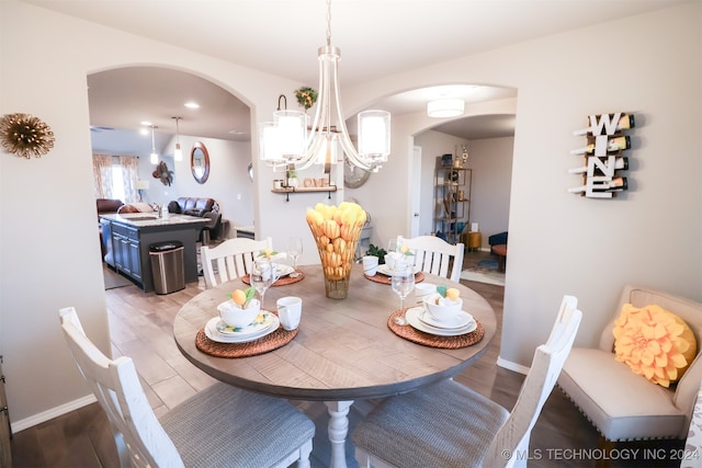 dining area with hardwood / wood-style flooring and a chandelier