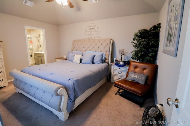 bedroom with ceiling fan, light colored carpet, and ensuite bath