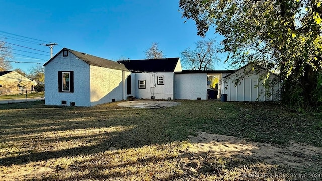 back of property with a lawn and a patio area