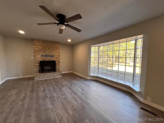 unfurnished living room featuring a fireplace, wood finished floors, visible vents, and baseboards