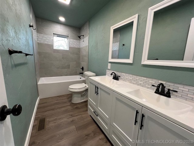 full bathroom with visible vents, a sink, backsplash, and wood finished floors