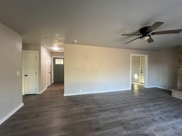 unfurnished room with dark wood finished floors, baseboards, and ceiling fan