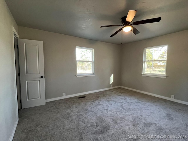 spare room with carpet, visible vents, ceiling fan, and baseboards