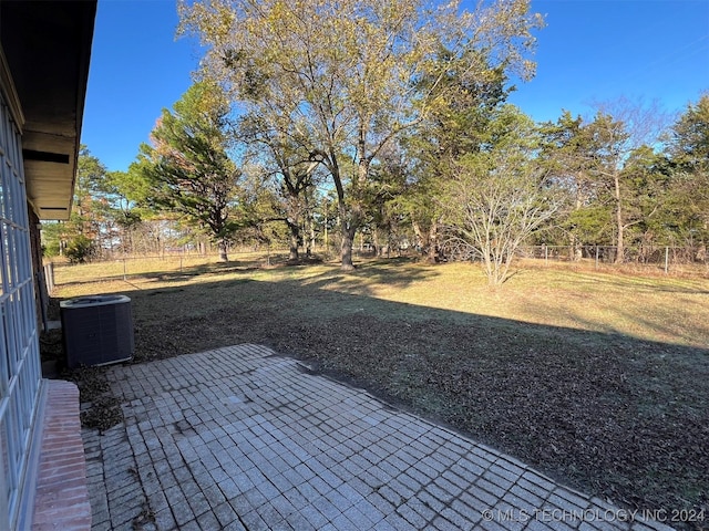 view of yard featuring cooling unit, a fenced backyard, and a patio