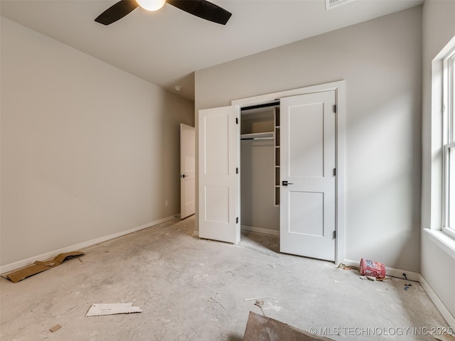 unfurnished bedroom with ceiling fan and a closet